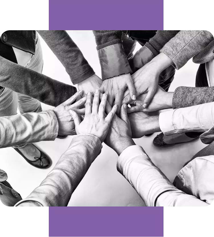 A group of people holding hands in the middle of a circle.