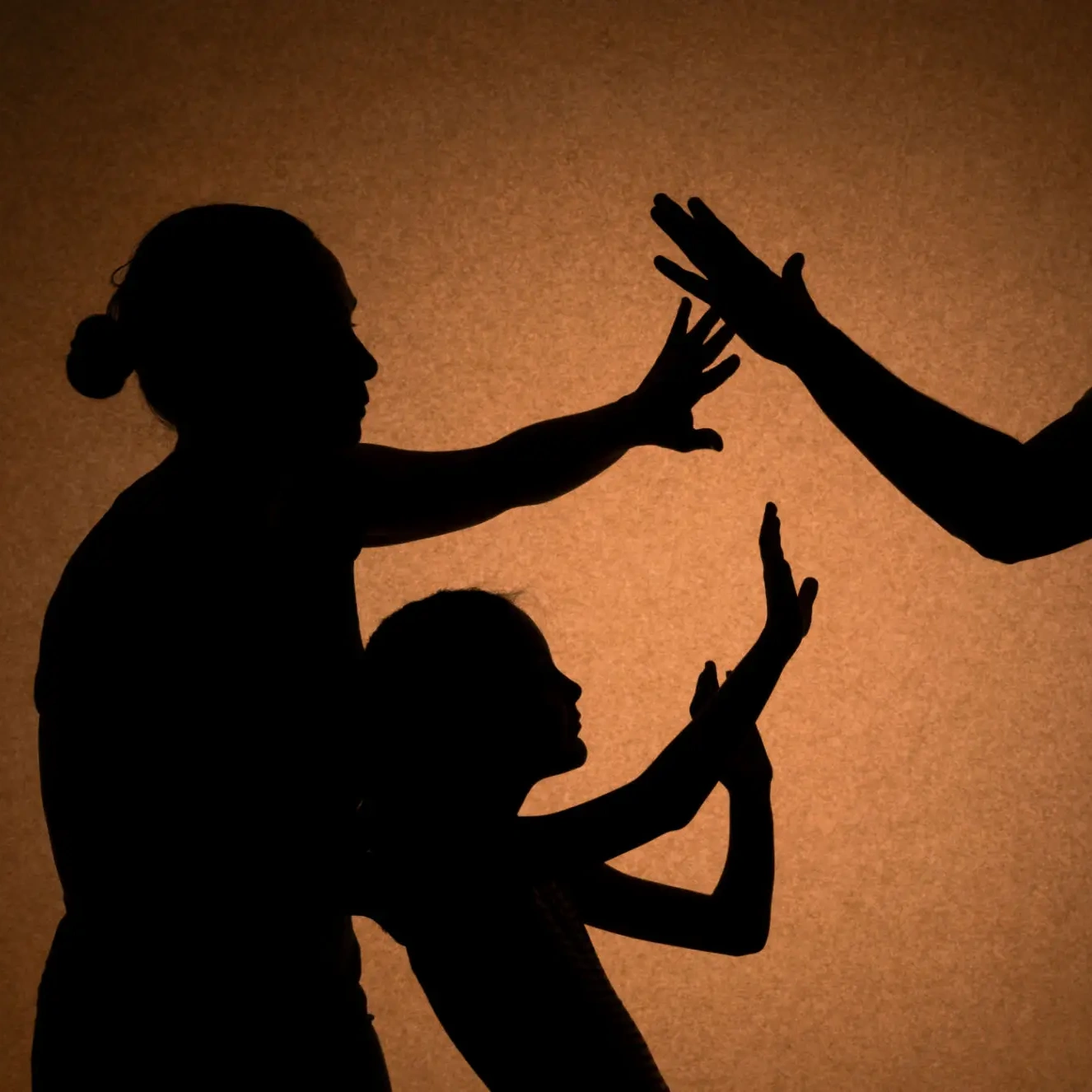 Family hand shadows against orange background