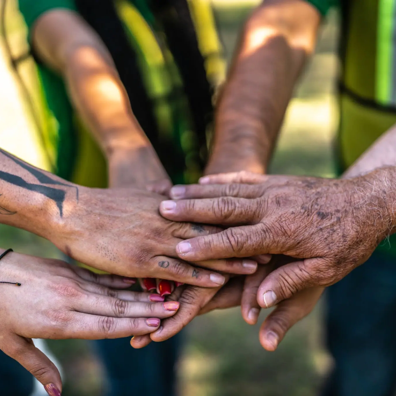 Diverse hands stacked together outdoors