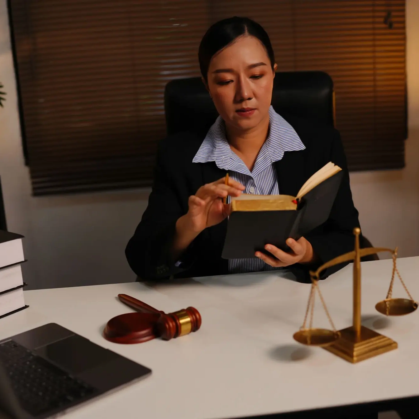 Woman studying legal book at desk