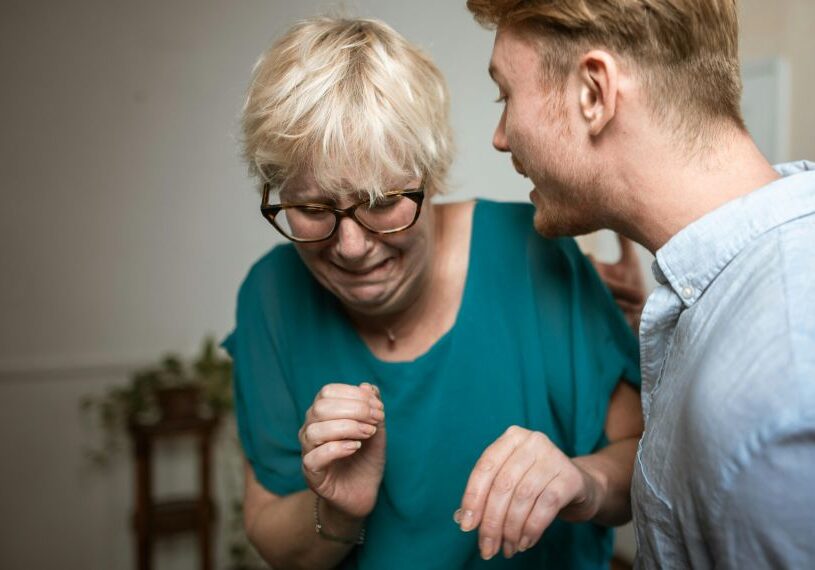 A woman and man laughing together in the living room.